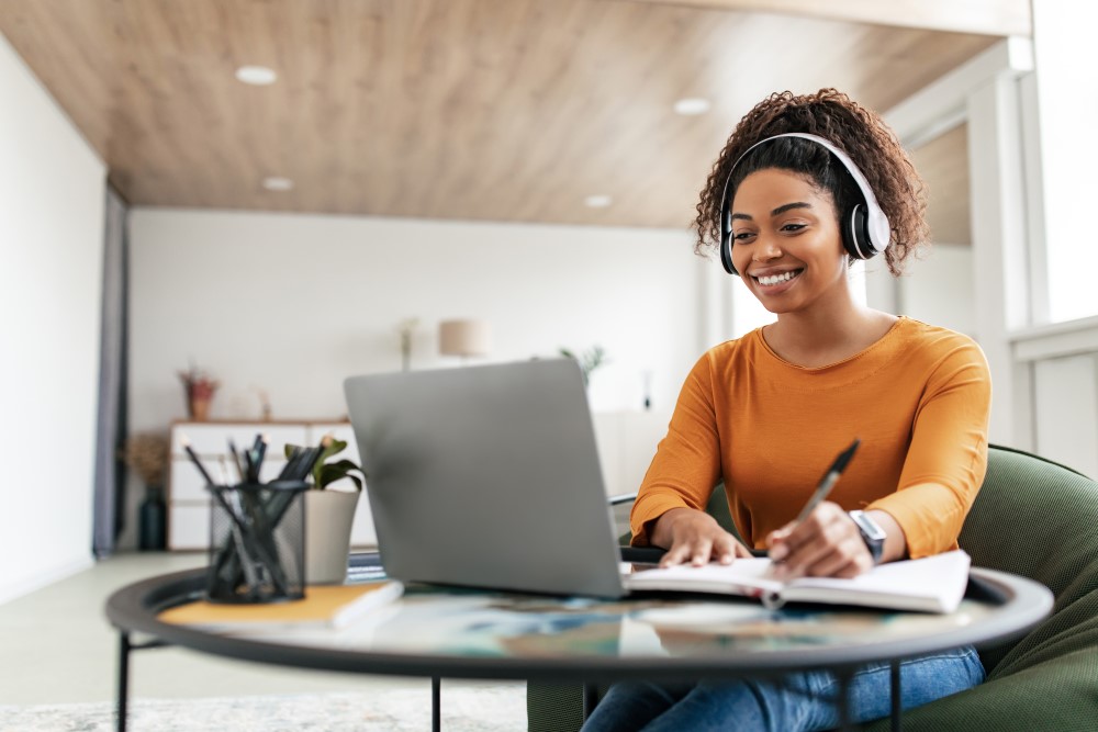 woman-sitting-desk-using-computer-writing-notebook-small